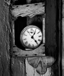 Reloj dentro de una caja de madera colgado en una pared