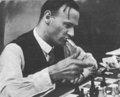 Fritz Sämisch fumando mientras va a realizar una jugada en una partida