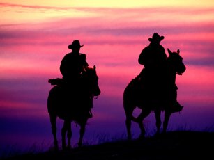 Silueta de dos vaqueros durante el atardecer