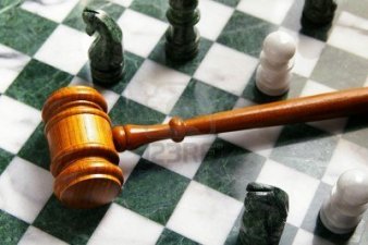 Mazo de juez sobre un tablero de ajedrez de marmol verde y blanco