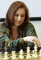 Judit Polgar, con una sonrisa, ante el tablero antes de comenzar la partida