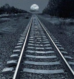 Vía de tren con la luna al fondo