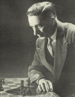 Edward Lasker posando ante un tablero de ajedrez