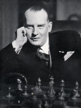 Alexander Alekhine posando ante un tablero de ajedrez